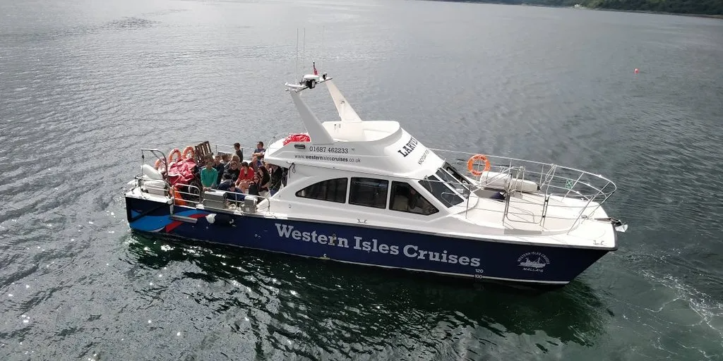 Cruise boat on water with passengers and 'Western Isles Cruises' text on side.