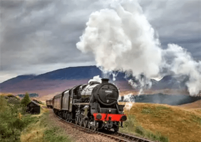 imgi_36_Jacobite-Steam-Train Steam train travels through scenic countryside with hills and cloudy sky.