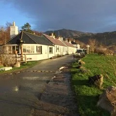 Row of cottages on a country road with mountains in the background.