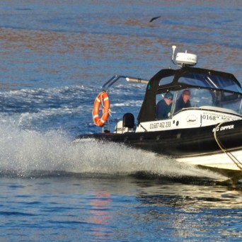 a man riding on the back of a boat in a body of water