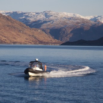 a small boat in a body of water with a mountain in the background
