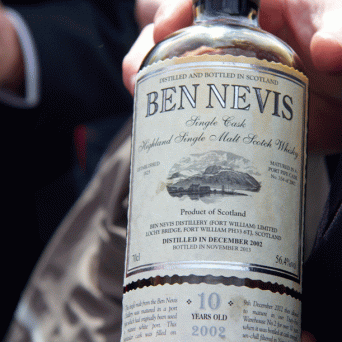 a hand holding a bottle of wine