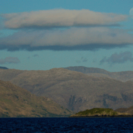 a large body of water with a mountain in the background