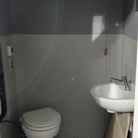 a white sink sitting under a mirror