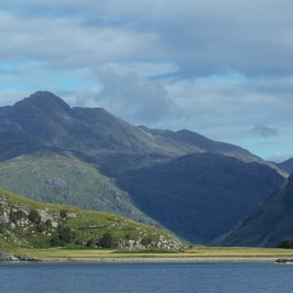 a large body of water with a mountain in the background