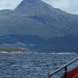 a small boat in a body of water with a mountain in the background