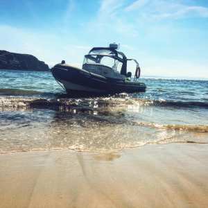 a boat sitting on top of a sandy beach next to the ocean