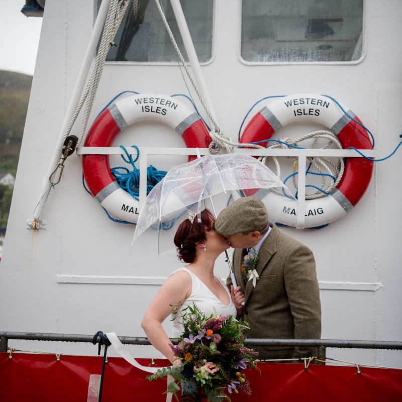 a man and a woman standing in front of a boat