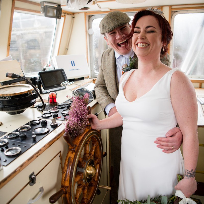 a person cutting a wedding cake