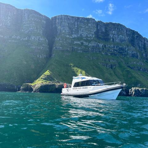 a small boat in a body of water with a mountain in the background